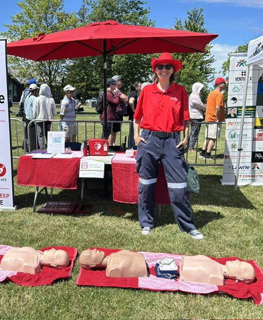 CPR workshop participants practising with mannequins and a trainer AED